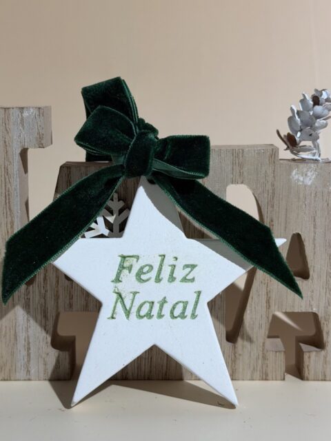 Estrela decorativa de Natal em gesso com laço de veludo e inscrição “Feliz Natal” em glitter, ideal para decoração natalina sofisticada e artesanal.