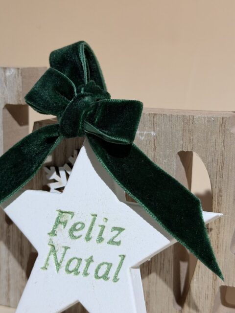 Estrela decorativa de Natal em gesso com laço de veludo e inscrição “Feliz Natal” em glitter, ideal para decoração natalina sofisticada e artesanal.