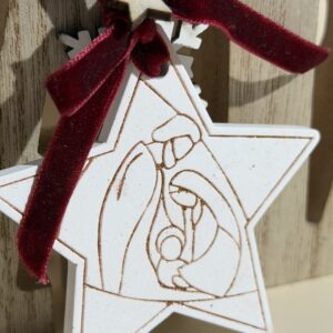 “Enfeite natalino artesanal em forma de estrela com ilustração da Sagrada Família gravada em madeira, detalhe em laço de veludo e estrela decorativa – ideal para decoração de Natal com significado religioso e estilo minimalista”