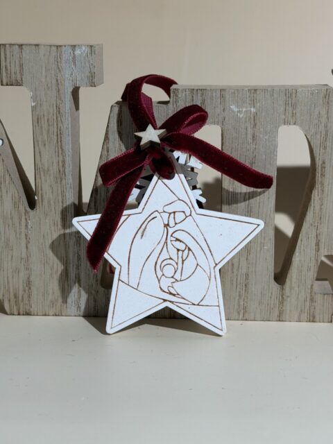 “Enfeite natalino artesanal em forma de estrela com ilustração da Sagrada Família gravada em madeira, detalhe em laço de veludo e estrela decorativa – ideal para decoração de Natal com significado religioso e estilo minimalista”