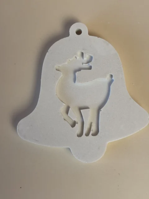 Pendente branco em forma de sino, decorado com uma rena de perfil e com um orifício no topo.
