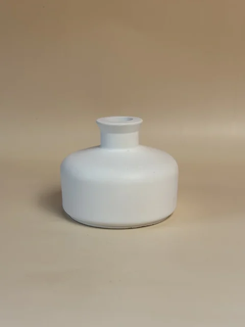 Jarra branca baixa em forma de botija, com corpo largo e gargalo curto, vista de frente.