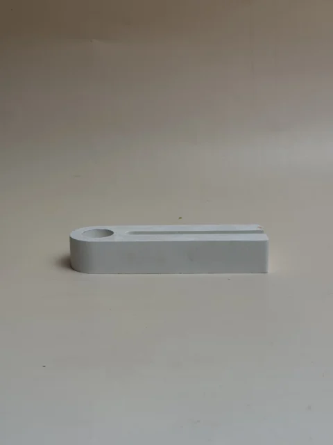 Porta-velas geométrico branco, retangular, com cavidade para vela e ranhura, visto de lado